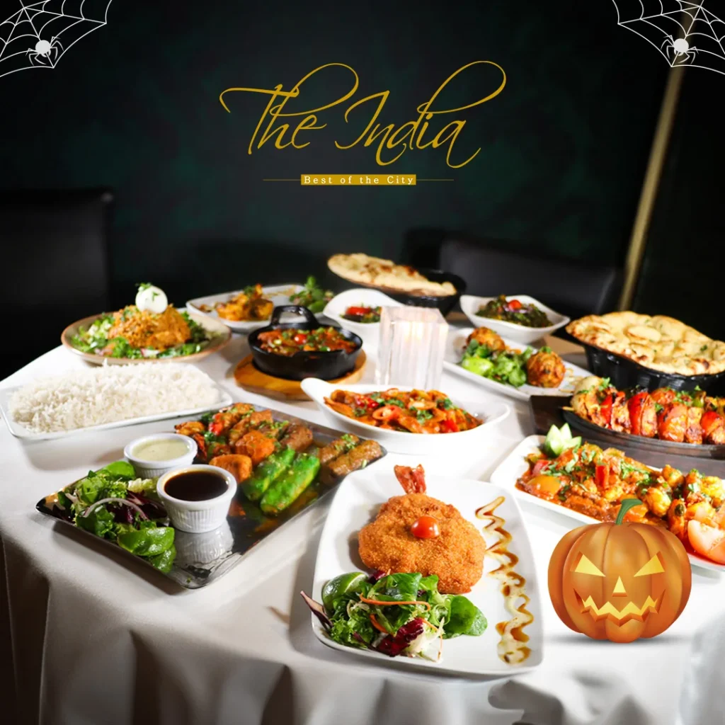 A table set for a Halloween dinner, adorned with themed decorations, candles, and festive dishes